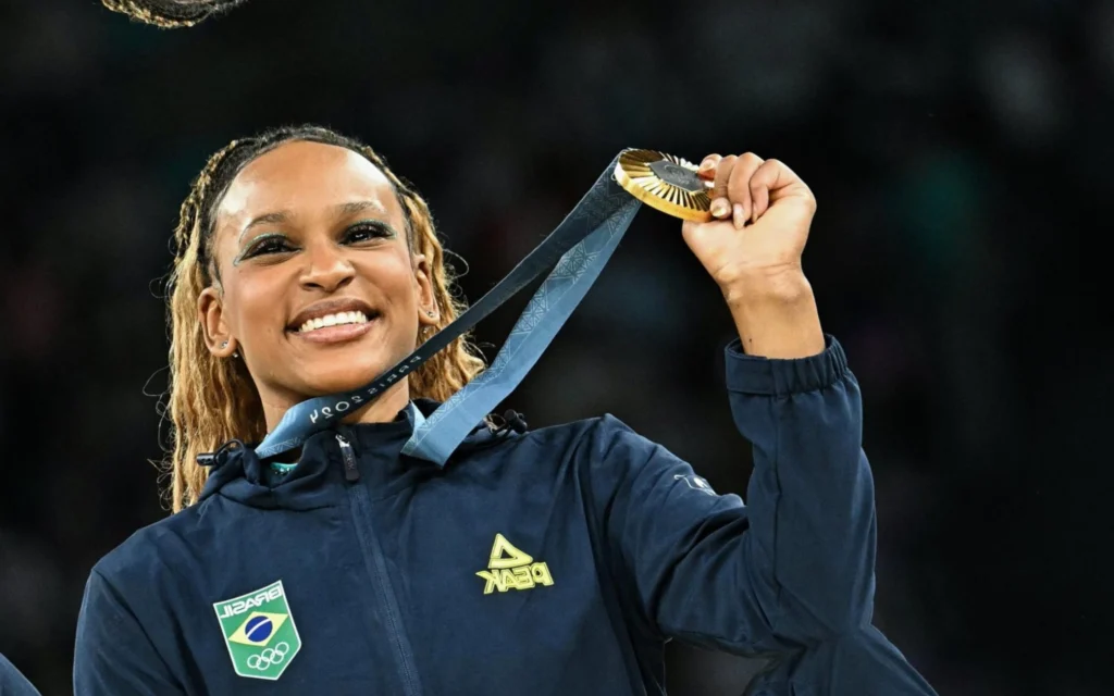 Psicóloga de Rebeca Andrade explica preparação mental da ginasta: ‘Exemplo de autocuidado’ Rebeca Andrade mostra a medalha de ouro conquistada nas Olimpíadas de Paris (Foto: Gabriel Bouys / AFP)